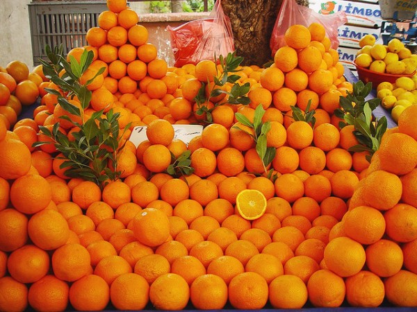 Você já viu, na feira, laranjas empilhadas desta maneira? A partir de uma camada inicial, os feirantes vão adicionando as camadas seguintes, de modo a que as laranjas da camada de cima sempre recaiam nos espaços deixados entre cada três laranjas da camada de baixo. Este é um arranjo estável, porque seria necessário erguer a laranja para tirá-la desta posição. (foto: Flickr / one2c900d / <a href=http://creativecommons.org/licenses/by-nd/2.0>CC BY-ND 2.0</a>)