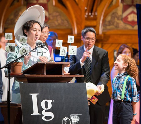 Premiados pela descoberta de que uma galinha pode andar como um dinossauro, vencedores do Ig Nobel de Física se divertem ao receber o troféu. (foto: divulgação/Ig Nobel)