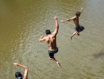 Meninos mergulhando num lago